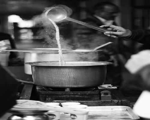 A vendor cooking fresh Pad Thai in a hot wok on the street